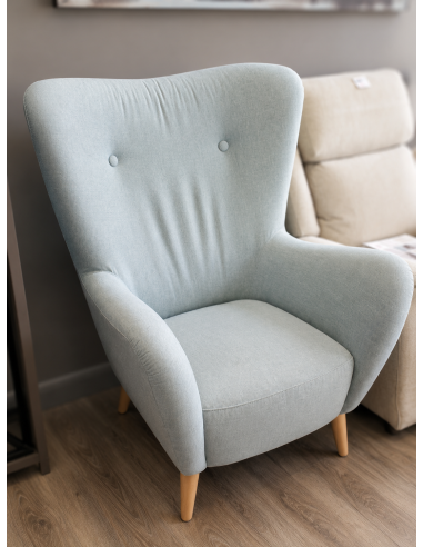 Sillón orejero azul claro con patas...